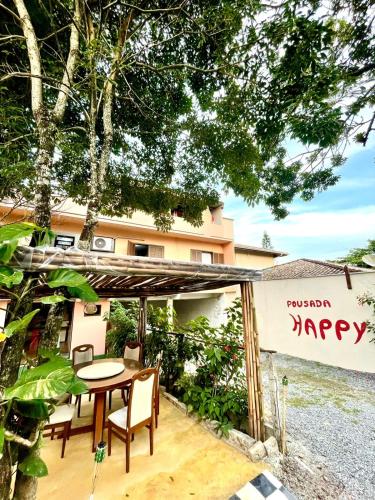 a patio with a table and chairs in front of a building at Pousada Happy 300m da Praia do Itaguaçú in São Francisco do Sul