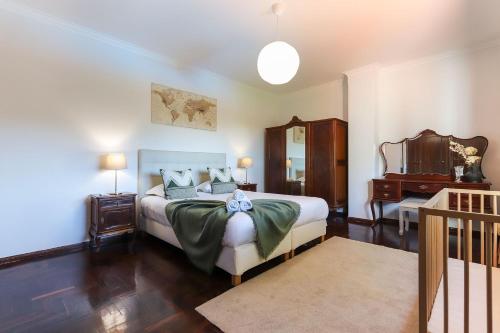 a bedroom with a bed and a dresser and a desk at Vita Portucale ! Sintra Retreat Villa with Pool in Sintra