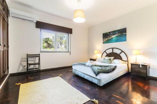 a bedroom with a bed and a table and a window at Vita Portucale ! Sintra Retreat Villa with Pool in Sintra