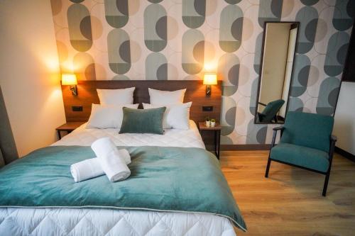 a bedroom with a bed and a chair and a mirror at KoonTy - Chambres et Appartements à Landerneau in Landerneau