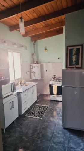 a kitchen with a refrigerator and a stove at hena apart 1 in Esquel