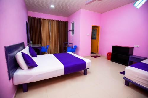 a pink bedroom with a bed and a tv at Bevary Guest in Anuradhapura