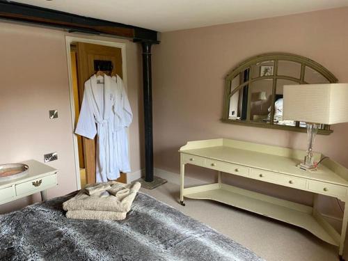 a bedroom with a dressing table and a mirror at Beautiful Stamford Townhouse with River Views in Lincolnshire