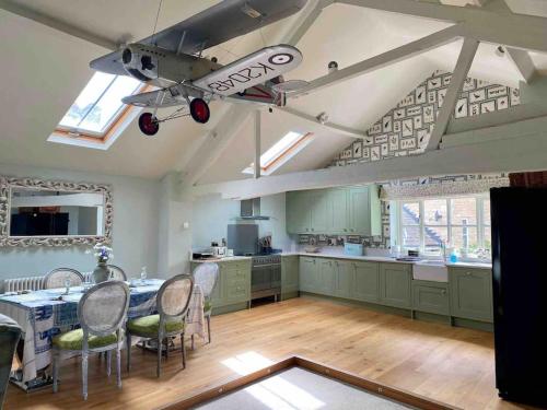 a kitchen with a table and a plane hanging from the ceiling at Beautiful Stamford Townhouse with River Views in Lincolnshire