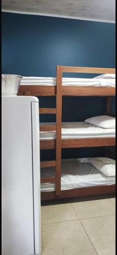 a room with three bunk beds and a refrigerator at Suite S3 in Bertioga