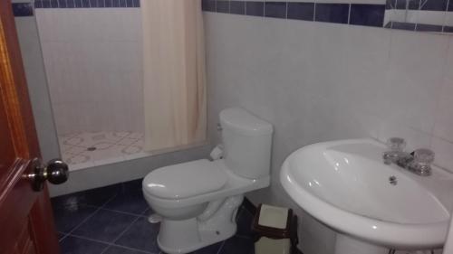 een badkamer met toilet, wastafel en douche bij Kibo Hotel in Ayacucho