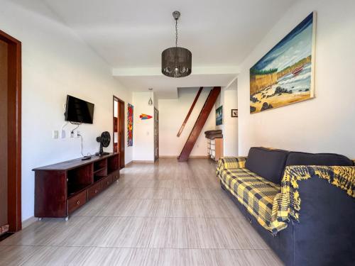 uma sala de estar com um sofá e uma TV em Casa no Centro de Pipa - Casa Laranja em Pipa