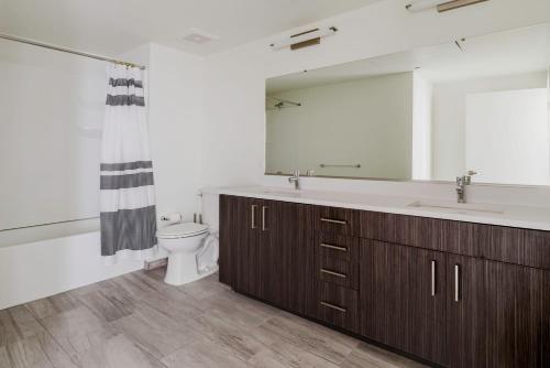 a bathroom with a sink and a toilet and a mirror at Blueground Hayward on-site retail restaurants SFO-1703 in Hayward