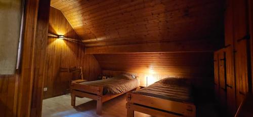une chambre avec deux lits dans une cabane en bois dans l'établissement Chalet les Alpages vue panoramique sur le lac Léman, à Thollon-les-Mémises