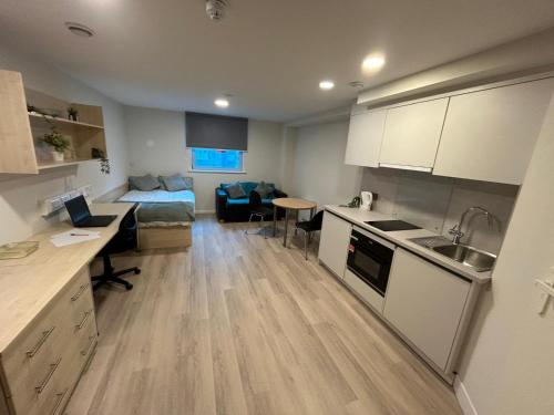 a kitchen and living room with a bed and a table at For Student Only Trinity Square in Nottingham in Nottingham