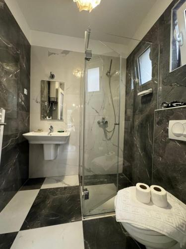 a bathroom with a shower and a toilet and a sink at Marinero Apartments in Budva