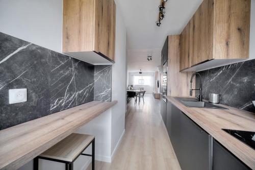 une cuisine avec des armoires en bois et un comptoir dans l'établissement 3 PIECES MODERNE PROCHE MARTINEZ et PLAGES A2B249, à Cannes