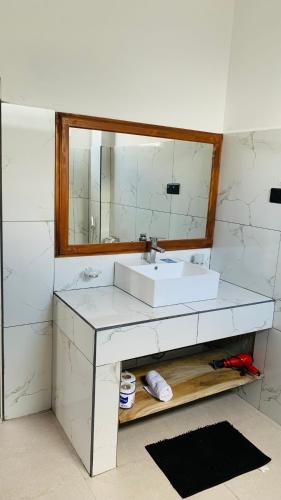 a bathroom with a white sink and a mirror at Mountain Paradise Bliss Guest House in Haputale