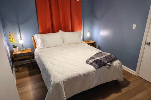 a bedroom with a bed and two tables with lamps at Kitchen, Laundry & Fenced Yard in New Bern