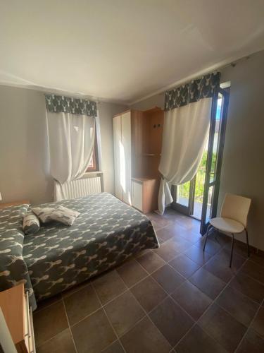 a bedroom with a bed and a chair and a window at Appartamento Frabosa in Frabosa Soprana