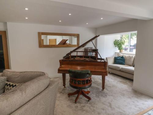 a living room with a piano and a couch at The Old Chapel in Gainsborough