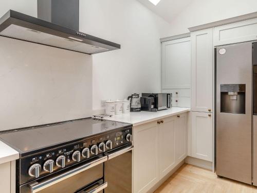 a kitchen with stainless steel appliances and white cabinets at The Old Chapel in Gainsborough