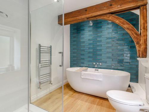 a bathroom with a bath tub and a toilet at The Old Chapel in Gainsborough