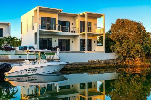 a boat is docked in front of a house at Balfour Villa in Turtle Cove