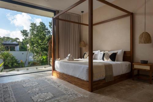 ein Schlafzimmer mit einem großen Bett und einem großen Fenster in der Unterkunft Stylish 5BR Villa for Bachelorette Aldea Zama in Tulum