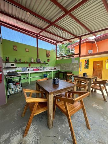 a dining room with wooden tables and green walls at Hotel Sueños de María in Uvita