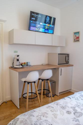 une cuisine avec deux tabourets et une table avec un four micro-ondes dans l'établissement Centre historique de Vitré avec garage, à Vitré