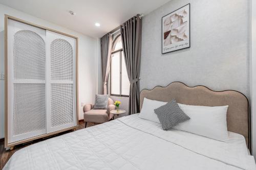 a bedroom with a bed and a chair and a window at Lotus Lalala Inn Hotel in Ho Chi Minh City