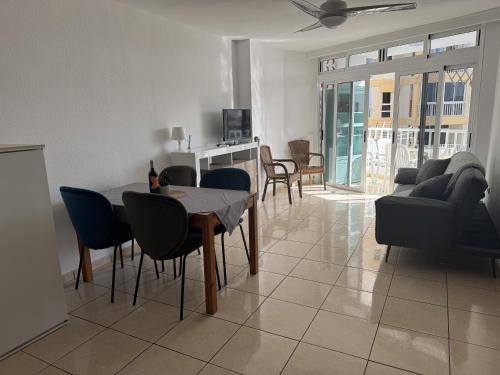 a living room with a table and chairs and a couch at Las Americas Stunning Apartment Close to the Sea in Tenerife in Arona