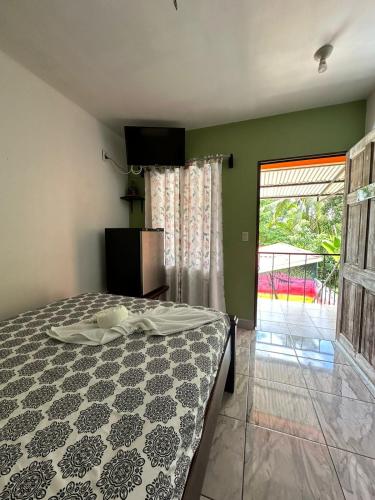 a bedroom with a bed and a sliding glass door at Hotel Sueños de María in Uvita