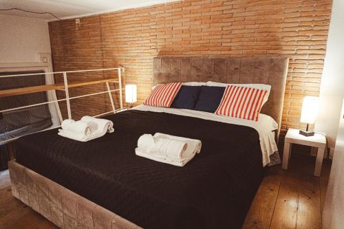 a bedroom with a bed with two towels on it at Old Town Nest in Civitavecchia in Civitavecchia