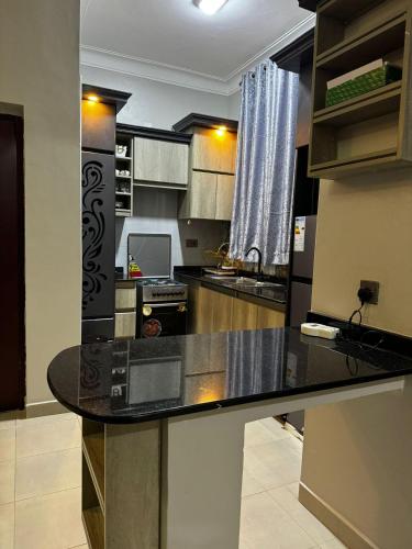 a kitchen with a black counter top in a room at 1 bed-uganda-2people-wifi-closetocity-parking in Makerere