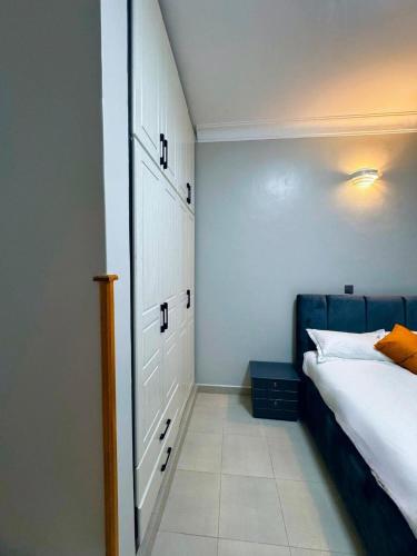 a bedroom with a white bed and a blue cabinet at 1 bed-uganda-2people-wifi-closetocity-parking in Makerere
