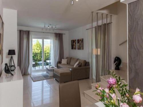 a living room with a couch and a large window at Beautiful Villa surrounded by Greenery with Swimming Pool in Gruda