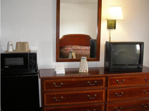 a room with a microwave and a television on a dresser at Knights Inn Center Valley in Center Valley