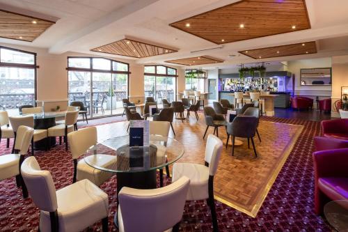 a restaurant with chairs and tables and a bar at The Norfolk Lodge Hotel in Saint Helier Jersey
