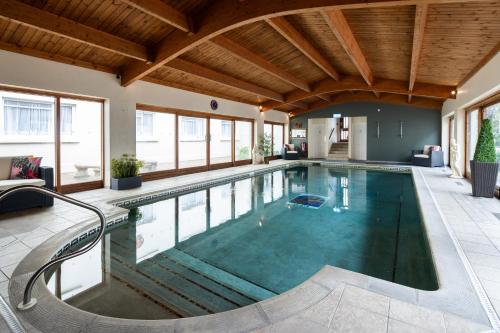 an indoor swimming pool with a wooden ceiling at The Norfolk Lodge Hotel in Saint Helier Jersey