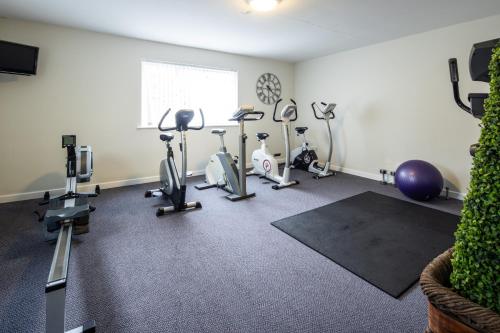 a gym with several exercise bikes and exercise balls at The Norfolk Lodge Hotel in Saint Helier Jersey