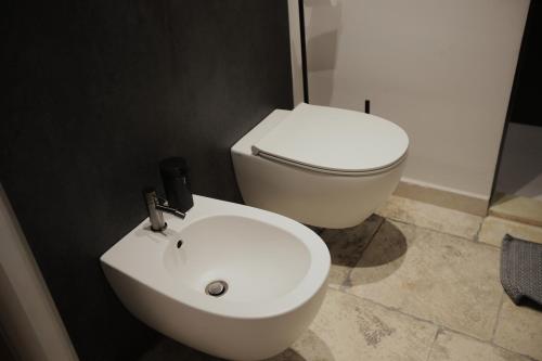 a bathroom with a white toilet and a sink at Chez Liart 2 in Fasano