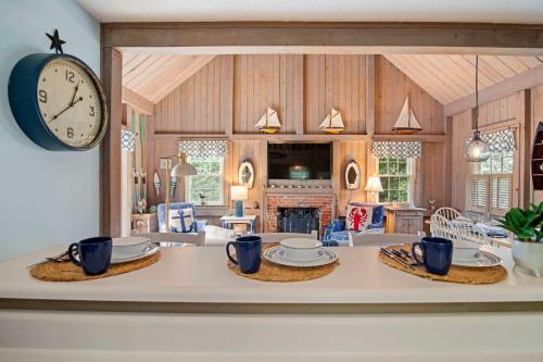 a kitchen and living room with a large clock on the wall at 5 Min Walk to Swimmable Mill Pond Dog Friendly in Orleans