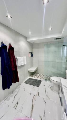 a bathroom with a toilet and a glass shower at The Happy Place in San Juan