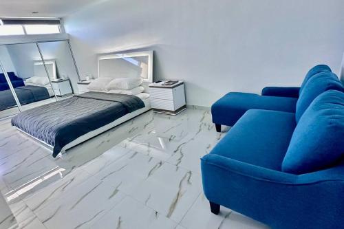 a bedroom with a blue couch and a bed at The Happy Place in San Juan