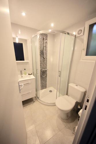 une salle de bain blanche avec douche et toilettes dans l'établissement Le Petit Pez, à Saint-Nazaire