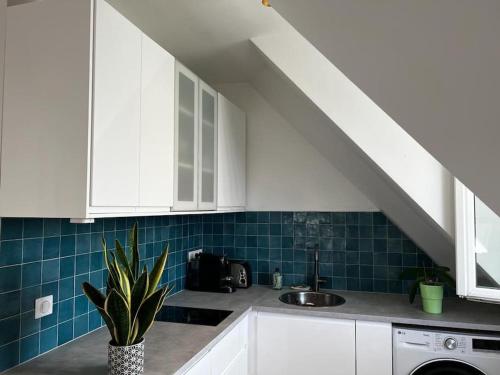 - une cuisine avec des placards blancs, un évier et un escalier dans l'établissement Apartment Paris Bail Mobility, à Paris