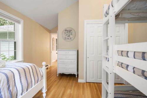 a bedroom with a white bunk bed and a white dresser at 2 Min to Mayflower Beach Dog Friendly in Dennis
