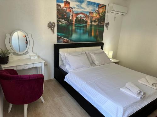 a bedroom with a bed and a mirror and a chair at Villa Zigana in Mostar
