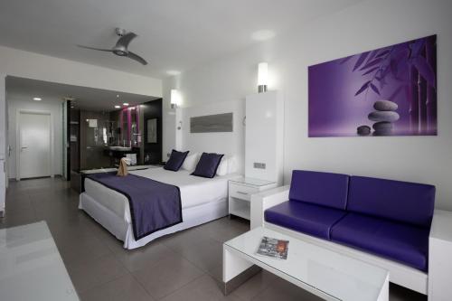 a hotel room with a bed and a couch at Riu Palace Antillas - Adults Only - All Inclusive in Palm-Eagle Beach