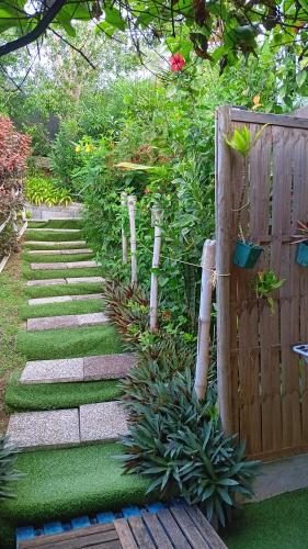 a garden with a pathway and a fence at Le LiloVert - Studio 24 m2 in Le Carbet