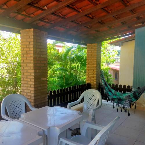 a patio with a hammock and tables and chairs at Villa Karina B&B in Itaparica Town