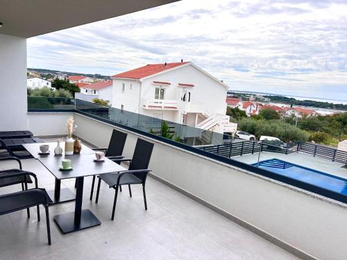 a balcony with a table and chairs and a pool at Boutique Hotel IVY'Z in Novalja