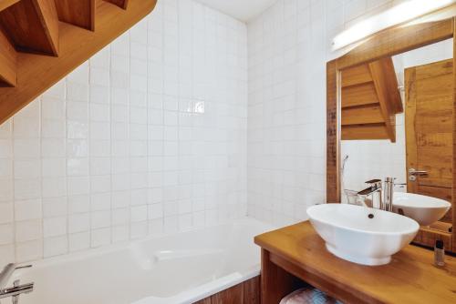 a bathroom with a white tub and a sink at Alliey & Spa Piscine Appart-hôtel Serre chevalier in Le Monêtier-les-Bains